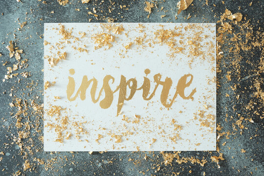 Inspire. Motivating Lettering On White Board. Handmade Creativity. Gold Letters. Gilding.