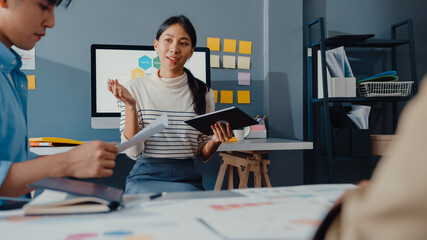 Happy young Asia businessmen and businesswomen meeting brainstorming some new ideas about project to his partner working together planning success strategy enjoy teamwork in small modern home office.