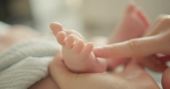 Tiny Newborn Baby's feet in mother hands. Mom and her Child. Happy Family concept.