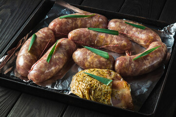Raw meat sausage and ham on a Sheet pan is prepared for baking in the oven. The national meat dish...