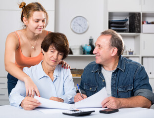 Marrieds is singing documents with their adult daughter at home.