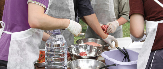 men cook meat on the street, you can only see men's hands