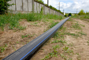 A plastic water pipe is lying on the ground