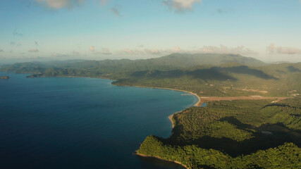 Fototapeta premium Aerial view coastline of tropical island and sea at sunrise. El nido, Palawan, Philippines. Seascape, island covered with forest in the morning. tropical landscape
