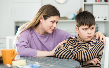 Mother wants to talk with his son after conflict at table in kitchen