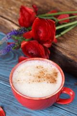 Cinnamon coffee in a red mug and red ranunculus
