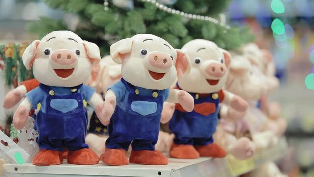 Three toy pigs on a shelf in the store.