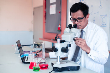 Science teacher    teaching with using computer and microscope in the classroom