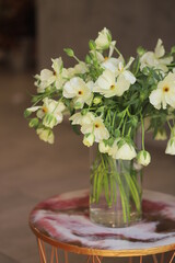 Bouquet of white ranunculus in glass vase.