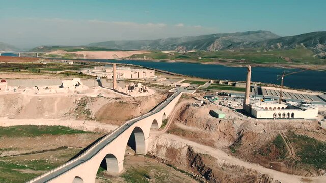 Aerial Shot of Restored old Roman Bridge In Hasan Keyf, Turkey. Hasankeyf village Southeastern Anatolia . Aerial view from the Fortress on the Tigris River. 12.04.2021
