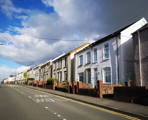 Street view of typical semi-detached houses on a Welsh street - with diminishing perspective and double yellow lines to prevent parking. 