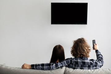 Family Watching TV Sitting On Couch At Home, Rear View