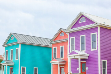 Two-story beach vacation houses in turquois, orange and purple.