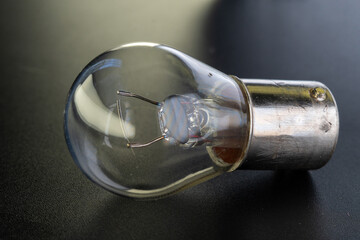 Car classic halogen bulb. Filament, glass and metal, high energy consumption. Black background....