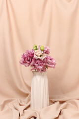 Eustoma flowers bouquet in vase in front of beige cloth background. Present for 8 March. Springtime concept with copyspace.