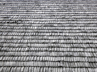 Traditional old roof made of natural wood tiles. Repeating pattern, gray background