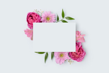 Floral frame made of alstroemeria and rose flower on a blue background. Paper card mockup. Festive concept for Mothers Day.