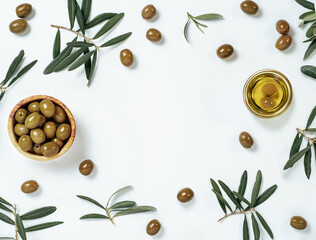 Olives and oil backgound with copy space. Set of green olives and extra virgin olive oil on white background. Top view of olives in wooden bowl and oil in glass bowl, leaves and branches on background