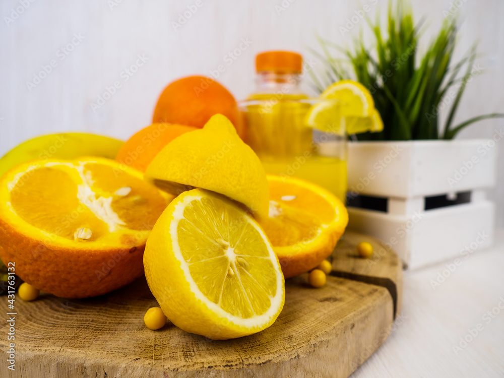 Wall mural ripe, juicy orange, lemon, tangerine and vitamin c lie on a wooden board. orange juice in a glass. f