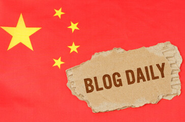 Against the background of the Chinese flag lies cardboard with the inscription - Blog Daily