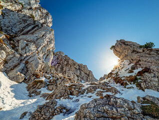 Top of the Chiemgau Kampenwand with a stunning view across the Bavarian Alps and mountain rocks at the foreground