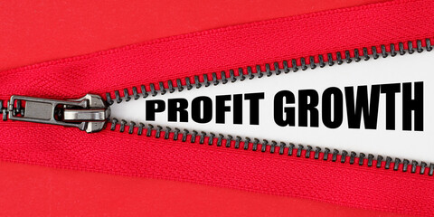 Against the background of red fabric, a zipper opens, on the white surface the inscription - PROFIT GROWTH