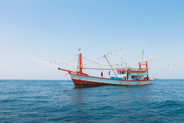 A Thai commercial fishing boat trawler on the open ocean water in the Andaman Sea in Thailand.