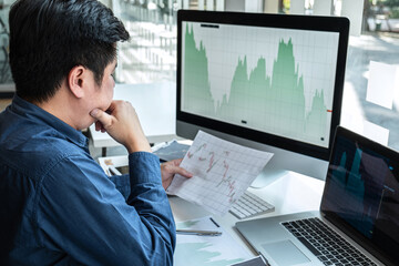 Businessman investor working in traders marketing and planning and analyzing pointing on the stock chart data presented and deal on a stock exchange to business profit