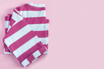 Striped pink T-shirt on paper background.