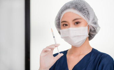 Cosmetologist wear face mask and holding injection syringe for preparing to face augmentation for anti wrinkle in beauty clinic.