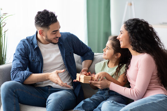 Portrait Of Cute Little Daughter And Wife Making Surprise For Arab Man