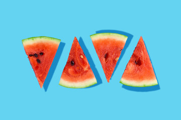 Creative food health diet concept photo of sliced watermelon fruit on blue background.