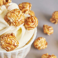 Milky cream cupcake. Birthday sweet bakery. Cookies. Yummy buttercream dessert. Wedding party food. Grey background. Holiday recipe. Anniversary gourmet. One pieces. Caramel popcorn