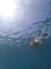 Silhouette of scuba diver and sunlight in the blue water