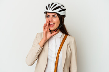 Young caucasian woman riding a bicycle to work isolated on white background shouting and holding palm near opened mouth.