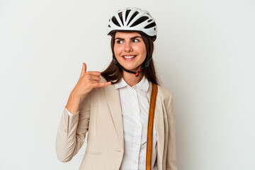 Young caucasian woman riding a bicycle to work isolated on white background showing a mobile phone call gesture with fingers.