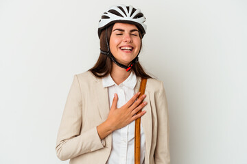 Young caucasian woman riding a bicycle to work isolated on white background laughs out loudly keeping hand on chest.