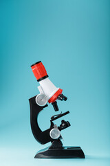 Microscope for laboratory medical research and experiments on a blue background.