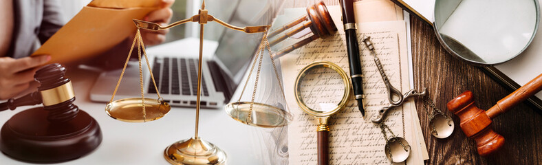 Justice and law concept.Male judge in a courtroom with the gavel, working with, computer and docking keyboard, eyeglasses, on table in morning light