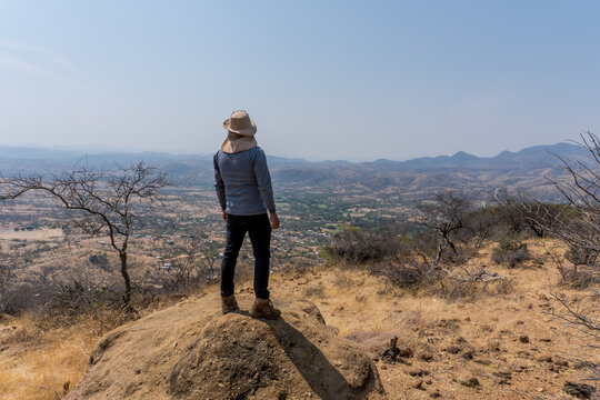 Traveler in a park with Lophocereus marginatus and bare trees in Mixteca Poblana, Puebla, Mexico