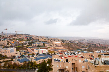 Fototapeta na wymiar view from the mountain to Jerusalem in cloudy weather. Cars, light stone houses