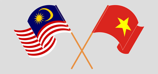 Crossed and waving flags of Malaysia and Vietnam