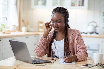 Smiling Black Female Student In Headset Watching Webinar On Laptop At Home