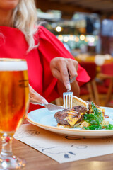 person eating at the restaurant with beer