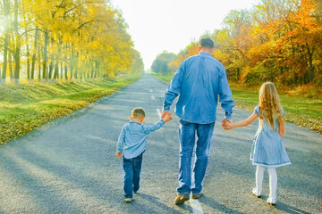 A Happy parent with child are walking along the road in the park on nature travel