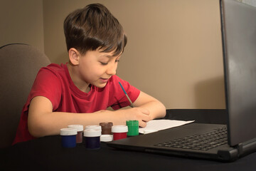 boy in an online paint drawing lesson. Children's creativity. Online School Distance Learning Concept