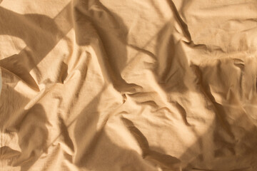 Abstract beige background flat layout. Modern minimalistic background with crumpled fabric texture and cotton folds. Top view for presentation