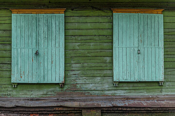 shuttered windows of an abandoned wooden building