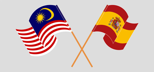 Crossed and waving flags of Malaysia and Spain