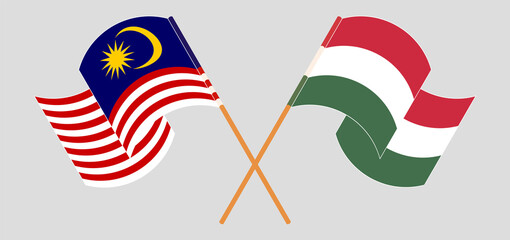 Crossed and waving flags of Malaysia and Hungary